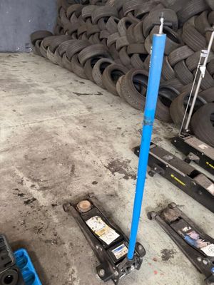 a pile of tires sitting on the floor next to a blue pole