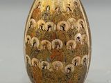 a gold vase with a picture of people on it
