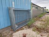 a metal fence that is leaning against the side of a building