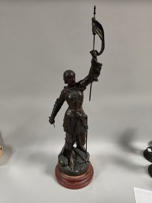 statue of a woman holding a flag on top of a table