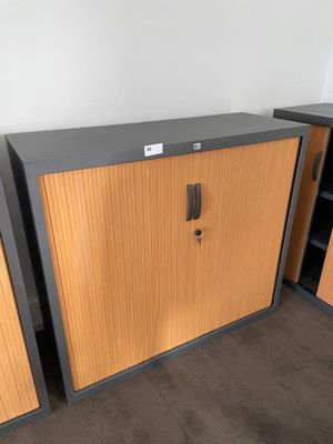 two wooden cabinets in the corner of a room