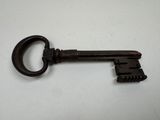 a close up of an old key on a white surface