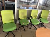 trois chaises de bureau vertes placées devant une fenêtre dans un bureau