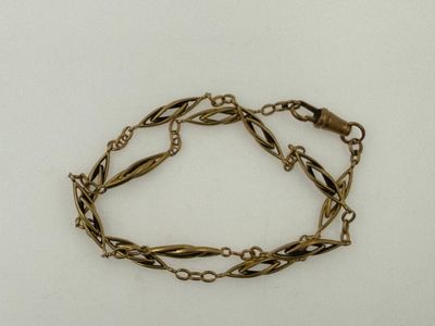 a close up of a bracelet with a chain on a white surface