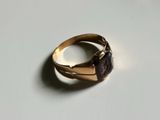 an image of a gold ring with a purple stone on it