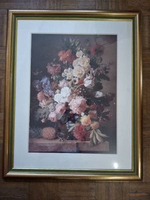 framed picture of a vase of flowers on a table in a room