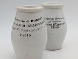 deux vases blancs portant une inscription noire sur fond blanc