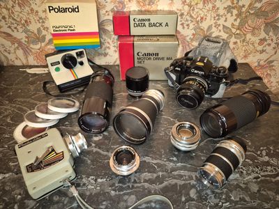 de nombreux appareils photo et objectifs différents posés sur la table