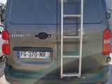 a silver van with a ladder attached to the back of it