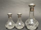 three glass bottles sitting next to each other on a table