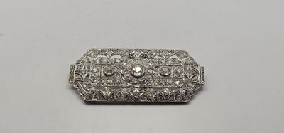 une broche en argent ornée d'un diamant au centre