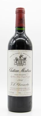une vieille bouteille de vin rouge posée sur une table blanche