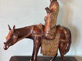 bronze statue of a woman riding a horse with a hat on her head