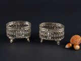 pair of silver plated bowls with acorns and nuts on a black background