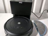 a black robotic vacuum cleaner sitting on a table next to a cleaning pad