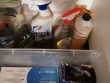 a plastic container filled with cleaning supplies on a table