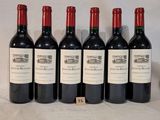 six bouteilles de vin sont alignées sur une table