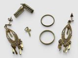 three pairs of earrings and a ring are shown on a white surface