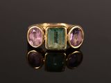 gros plan d'une bague en or avec trois pierres de couleurs différentes