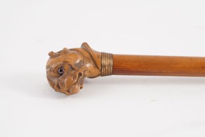 une vieille canne en bois surmontée d'une tête de lion