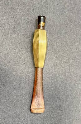 une cuillère en bois avec un manche en bois posée sur une surface grise