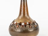 a brown vase that has a lot of dots on it