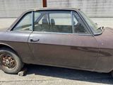 an old car that is sitting in the parking lot