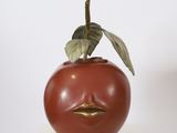 a sculpture of a tomato with a face on it