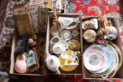 une boîte remplie d'objets divers, posée sur un tapis