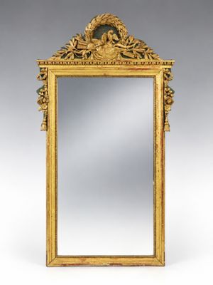 un miroir ancien dans un cadre doré, orné d'un motif représentant un oiseau et des fleurs