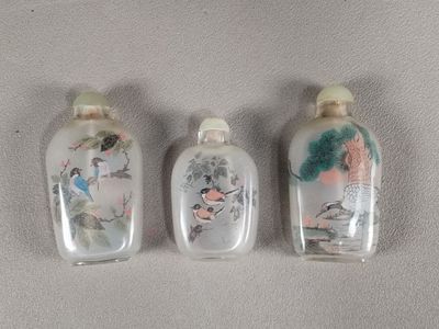 trois flacons à tabac en verre ornés de motifs d'oiseaux et de fleurs peints