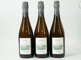 trois bouteilles de vin posées sur une table blanche