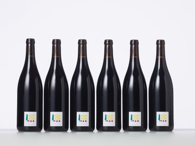 six bottles of wine lined up in a row on a table