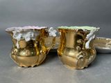 two gold vases sitting next to each other on a table
