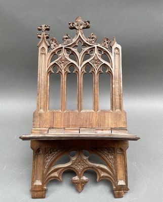 un vieux banc en bois dont le dossier présente un motif gothique