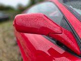 a close up of a red car ' s door handle