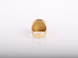 a gold ring on a white surface