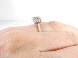 a person holding a diamond ring in their hand