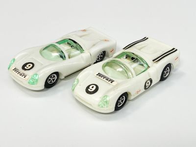 deux voitures jouets assises l'une à côté de l'autre sur une surface blanche