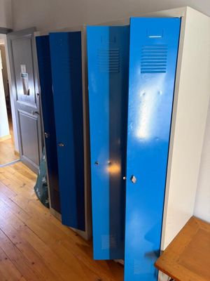 un casier bleu dans un coin de la pièce, à côté d'un bureau
