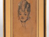 un vieux dessin représentant le visage d'une femme, dans un cadre doré