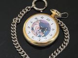 a pocket watch with a chain around it on a table