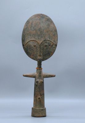 un vieil objet en métal sur lequel est représenté un visage