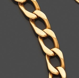 gros plan d'un bracelet en chaîne en or sur une surface noire