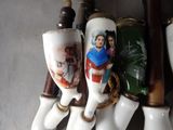 four porcelain toothbrushes with pictures of people on them