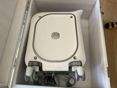 a white toilet with wheels in a box on the floor