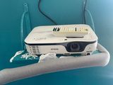 a projector on a towel rack with a plant in the background
