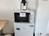 un micro-ondes posé sur un réfrigérateur dans une cuisine