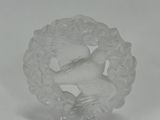 a close up of a glass figurine of a bird in a wreath