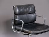an image of a black leather office chair against a gray wall